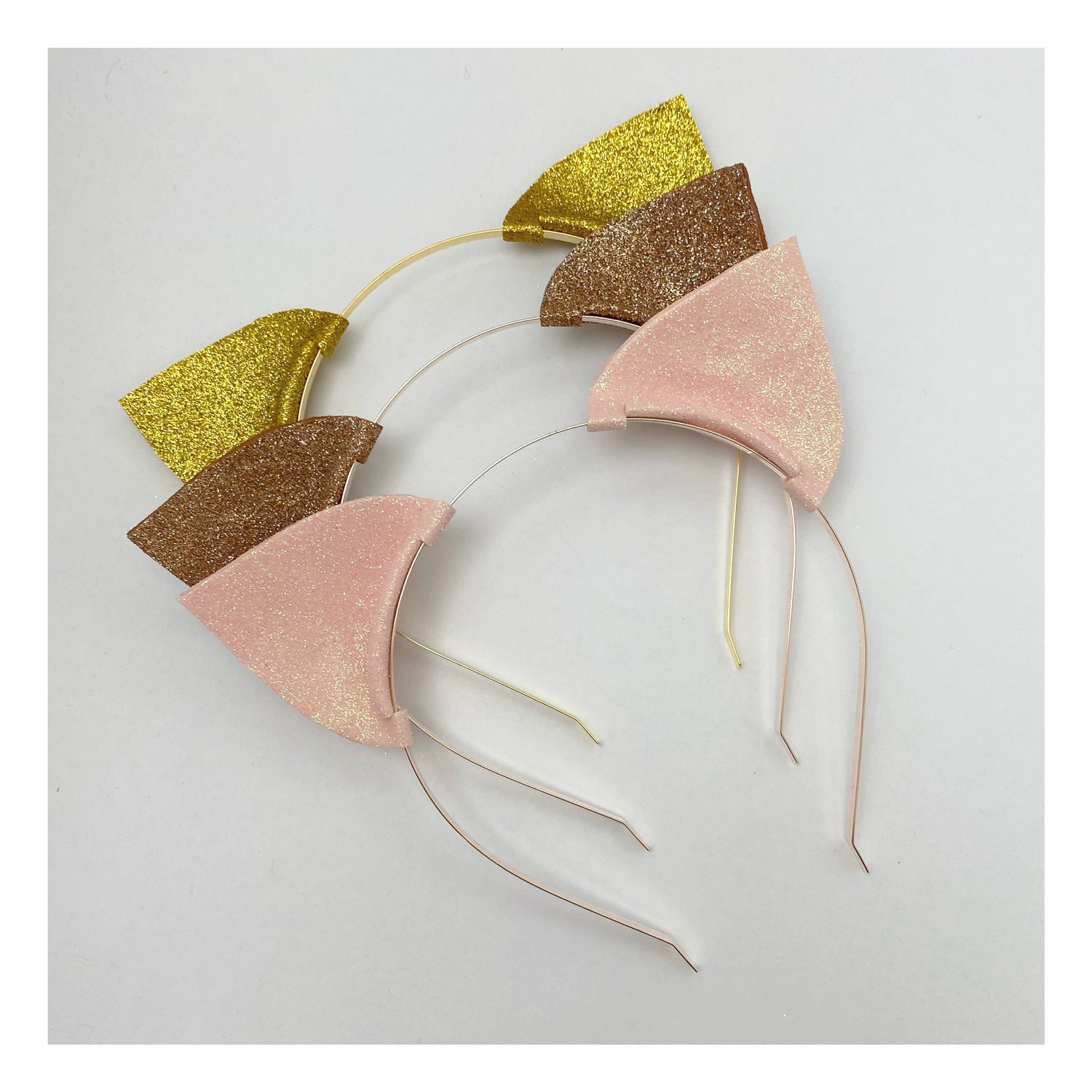 Glitter Cat Ear Headbands. Shown: light pink, stardust and gold. Slim metal headbands for easy wear.